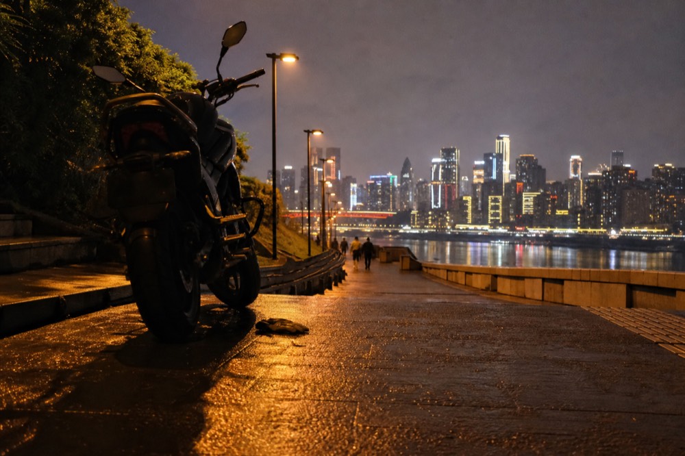 Riverside promenade at night with the illuminated towers of the opposite riverbank