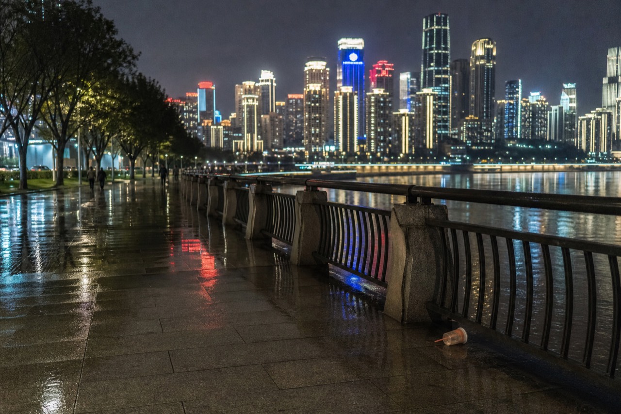 Chongqing riverside promenade at night with lit towers across the Yangtze River