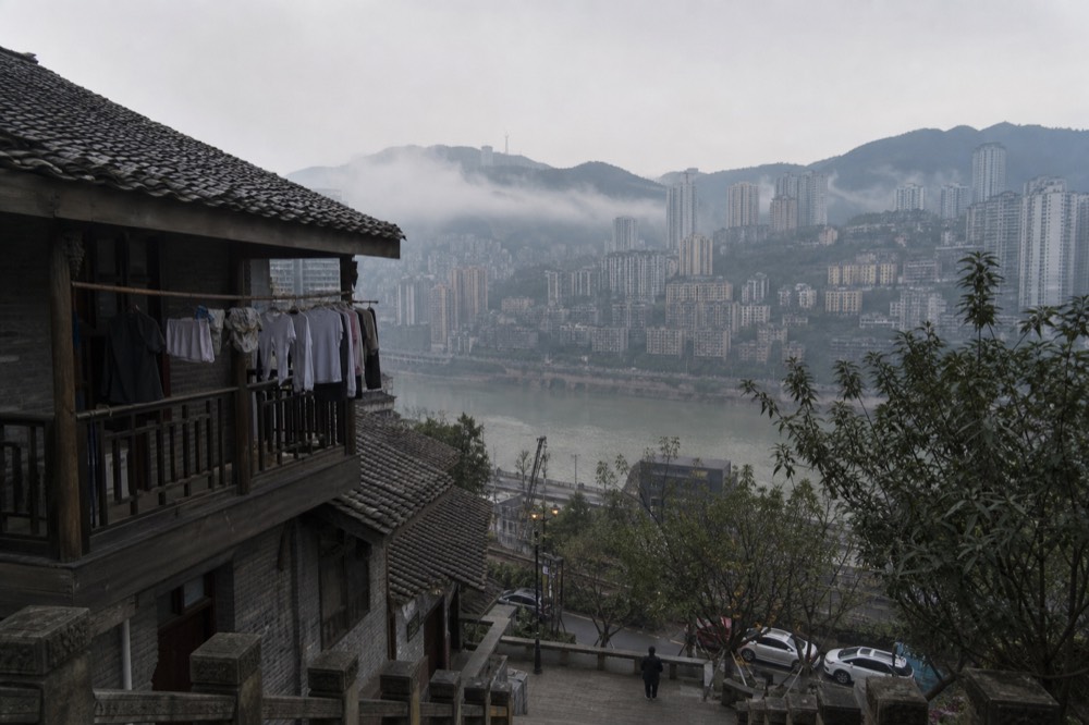 Mist drifting between hillside towers above a river at dawn