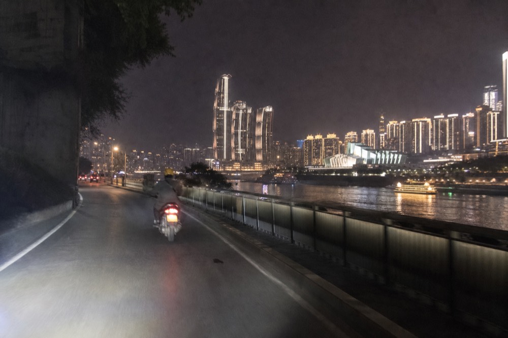 Motorcycle riding on a riverside road at night in Chongqing