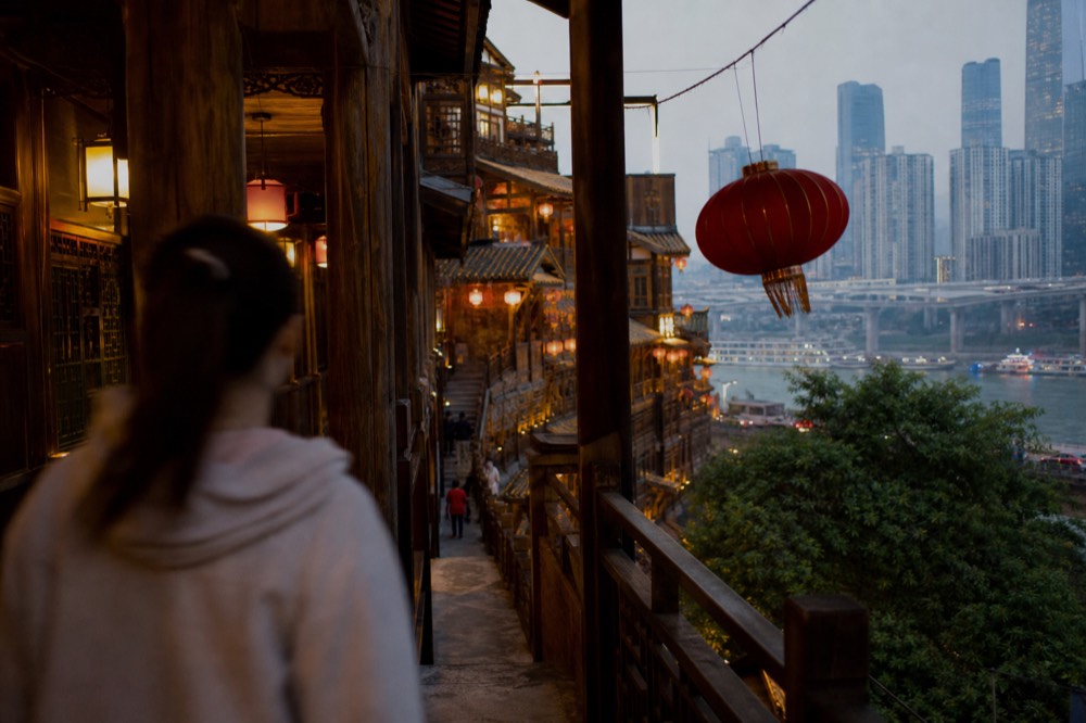 Warm lantern light on wooden walkways and balconies inside a multi-level building