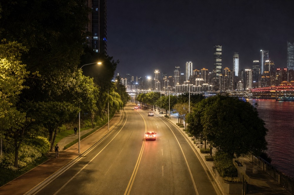 A wide view of Nanbin Road at night, with street lamps, traffic lanes and the lit Yuzhong skyline across the Yangtze River