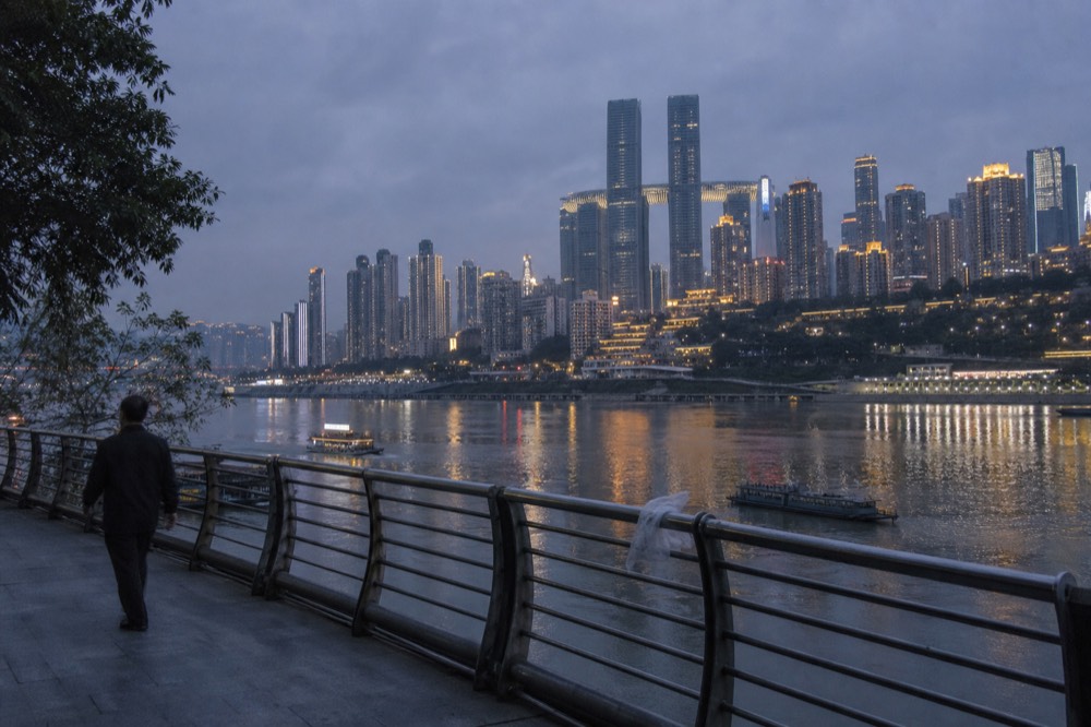 The Yuzhong peninsula skyline lighting up across the Yangtze River from Nanbin Road at blue hour