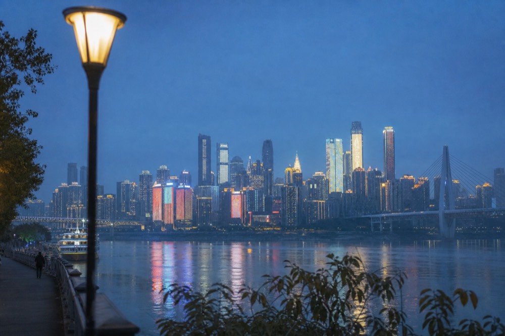 Deep blue evening sky above the illuminated towers of the Yuzhong peninsula across the Yangtze River